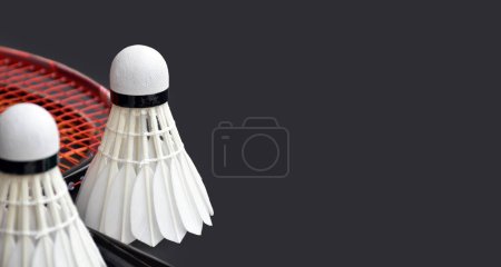 Téléchargez les photos : Navette de badminton blanc crème et raquette sur le sol dans le terrain de badminton intérieur, espace de copie, accent doux et sélectif sur les navettes. - en image libre de droit