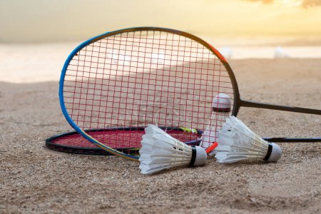 Photo for Badminton equipments, rackets and white cream shuttlecocks, on sand floor of outdoor badminton court, selective focus, concept for outdoor activity and outdoor sports for health. - Royalty Free Image