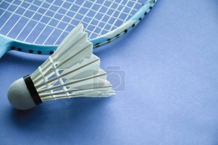 Photo for Badminton sport equipments, shuttlecock and racket, on light blue floor, blurred background, endurance sports concept. - Royalty Free Image