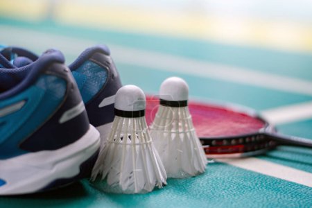 Badminton sport equipments, rackets, shuttlecocks, shoes, for exercising on pvc floor of indoor badminton court, soft focus, concept for badminton playing to loose weight all over the world.