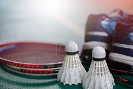 Badminton sport equipments, rackets, shuttlecocks, shoes, for exercising on pvc floor of indoor badminton court, soft focus, concept for badminton playing to loose weight all over the world.