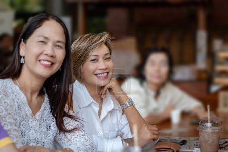 Asian female woman sitting and waiting to have lunch together while they are traveling together, selective focus on middle woman.