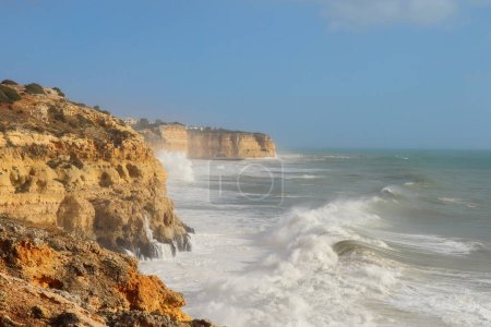 Large waves in the Atlantic Ocean and splashing on the cliffs on a warm, windy winter day in southern Portugal.