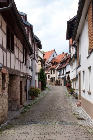 Weinheim, Germany - May 19, 2021: Historic half-timbered buildings on a cobblestone street in Weinheim, Germany.