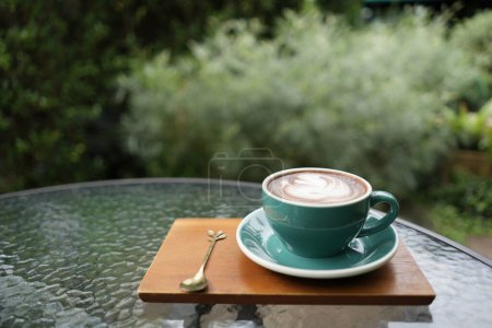 Foto de Taza de chocolate verde y cuaderno de cuero sobre mesa de vidrio chill relax al aire libre - Imagen libre de derechos