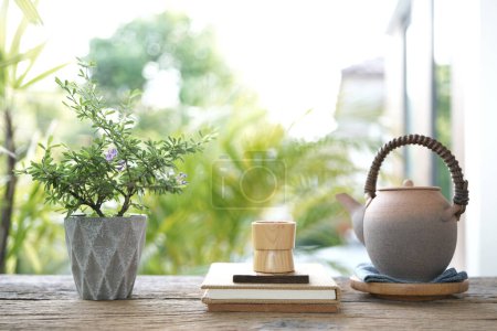 Téléchargez les photos : Petite tasse à thé en bois et poêle à thé en terre cuite et plante sur table en bois boire à l'extérieur - en image libre de droit