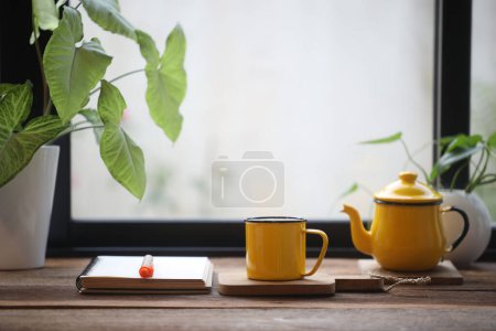 tasse jaune et ordinateur portable et fleurs blanches sur table blanche travail intérieur de la maison