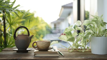 Teetasse und Steingut Teekanne auf dem Balkon und Laptop Seitenansicht