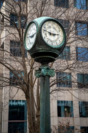 Photo for Hartford, CT - USA - Dec 28, 2022 Vertical image of an antique street clock bearing the name Hartford National Bank and Trust Company rises from the sidewalk in downtown Hartford. - Royalty Free Image