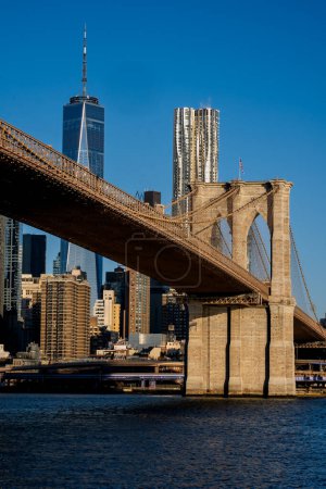 Photo for Brooklyn, NY - USA - March 26, 2023 Sunrise view of lower Manhattan, featuring the Brooklyn Bridge, World Trade Center, and Frank Gehrys 8 Spruce Street, seen from across the East River in Brooklyn - Royalty Free Image