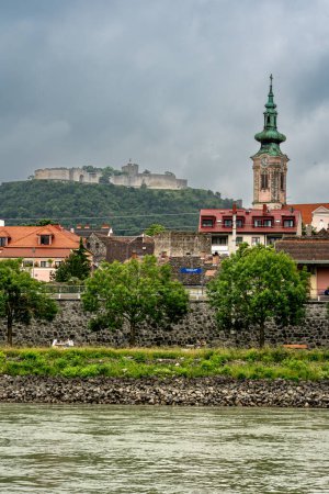 Photo for Hainburg an der Donau,  Lower Austria - AT - June 10, 2023 Vertical view of the town of Hainburg, located on the right bank of the Danube river. Hainburg Castle is on the mountain behind the town. - Royalty Free Image