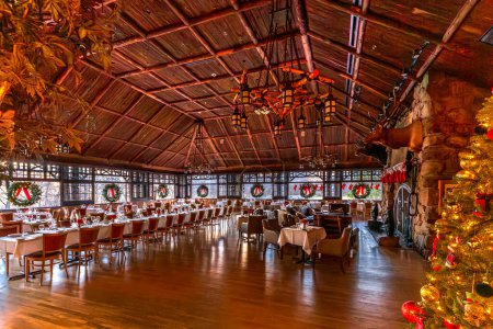 Photo for Bear Mountain, NY - US - Dec 30, 2023 Wide angle view of Restaurant 1915s rustic dining room in the historic Bear Mountain Inn during the Christmas season. Located in Bear Mountain State Park in NY - Royalty Free Image