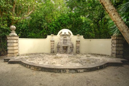 Téléchargez les photos : Fort Lauderdale, FL - US - 7 février 2024 Le paisible Bonnet House Museum et le feuillage luxuriant du jardin de l'Allee et sa majestueuse fontaine sèche, ornée de sculptures complexes et de motifs décoratifs. - en image libre de droit