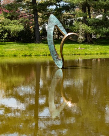 Foto de Purchase, NY US Apr 28, 2024 Wendy Tayors bronce moderno bufón de escultura; reflexionando sobre un estanque en el Donald M Kendall Sculpture Gardens en la sede central mundial de PepsiCo en Purchase. - Imagen libre de derechos