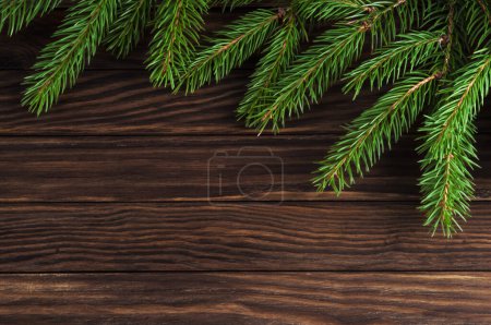 Téléchargez les photos : Fond de Noël vintage en bois avec des branches persistantes. Cadre vintage festif. - en image libre de droit