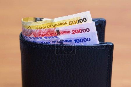 Dinero ugandés - chelín en la cartera negra