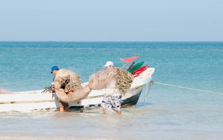 Foto de Pescadores llevando redes en el barco cerca de la playa. Isla Holbox México - Imagen libre de derechos