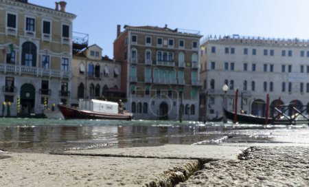 Téléchargez les photos : Vue floue des palais au bord du canal à Venise pendant le phénomène de marée haute dans la ville près du célèbre pont du Rialto - en image libre de droit