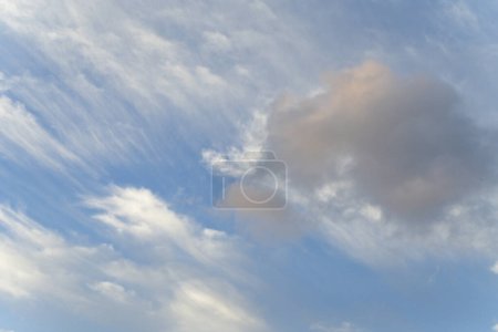 Eine ruhige Himmelsszene mit sanften orangefarbenen Wolken vor einem klaren blauen Hintergrund