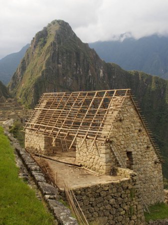 Foto de Restauración de la estructura de la cubierta en uno de los edificios antiguos en el Machu Picchu alto en los Andes peruanos - Imagen libre de derechos