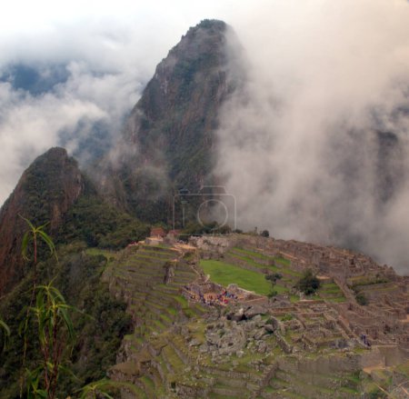 Foto de Nubes que descienden sobre las ruinas de Machu Picchu en lo alto de los Andes peruanos - Imagen libre de derechos