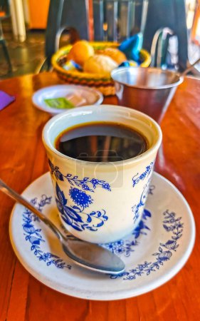 Foto de Taza azul y blanca con café negro americano sobre mesa de madera en El Cafecito en Zicatela Puerto Escondido Oaxaca México. - Imagen libre de derechos