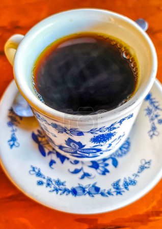 Photo for Blue and white cup pot with black coffee americano on wooden table in El Cafecito in Zicatela Puerto Escondido Oaxaca Mexico. - Royalty Free Image