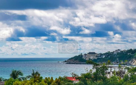 Beautiful natural panorama view with sea waves palm trees blue sky and beach in Zicatela Puerto Escondido Oaxaca Mexico.