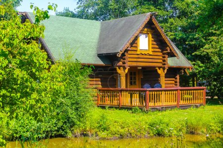 Brown vacation cottage house made of wood in nature forest in Hemmoor Hechthausen Cuxhaven Lower Saxony Germany.