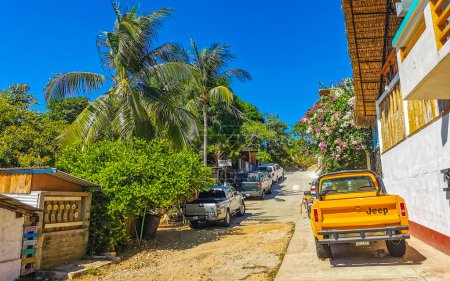 Photo for Colorful streets cars high traffic stores people buildings and trade in Zicatela Puerto Escondido Oaxaca Mexico. - Royalty Free Image