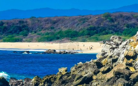 Téléchargez les photos : Beautiful rocks cliffs stones and boulders and huge big surfer waves and natural panorama view on the beach in Bacocho Puerto Escondido Oaxaca Mexico. - en image libre de droit