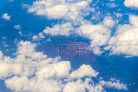 Photo for Flying by plane over Mexico with view of volcanoes mountains and clouds. - Royalty Free Image