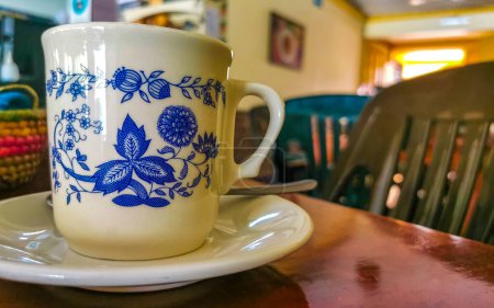 Foto de Taza azul y blanca con café negro americano sobre mesa de madera en El Cafecito en Zicatela Puerto Escondido México. - Imagen libre de derechos