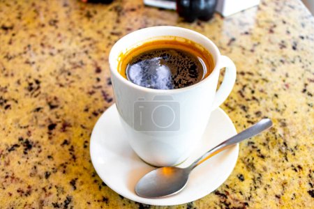 Téléchargez les photos : Coupe de café noir americano avec cuillère et assiette sur la table des aliments et des boissons dans le restaurant à Alajuela Costa Rica en Amérique centrale. - en image libre de droit