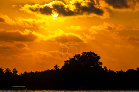 Foto de Isla paradisíaca tropical Kuramathi para vacaciones de lujo con palmeras de arena blanca aguas turquesas e increíble puesta de sol de colores dorados en el atolón Rasdhoo Maldivas. - Imagen libre de derechos