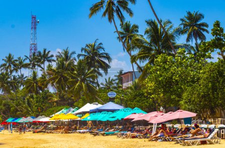 Photo for Mirissa Southern Province Sri Lanka 19. March 2018 Beautiful paradise tropical beach with waves sun loungers umbrellas parasols and tourists in Mirissa Beach Sri Lanka. - Royalty Free Image