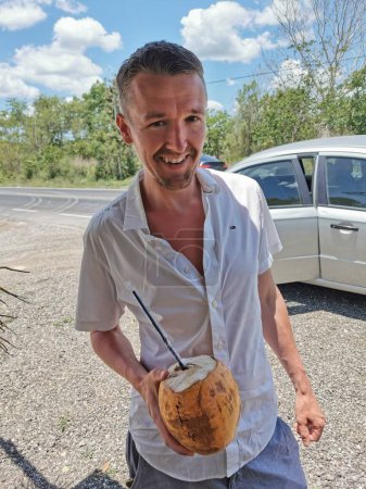 Foto de Hombre Hombre turista con coco en el puesto de coco bebiendo coco en Chiquila Lazaro Cárdenas en Quintana Roo México. - Imagen libre de derechos