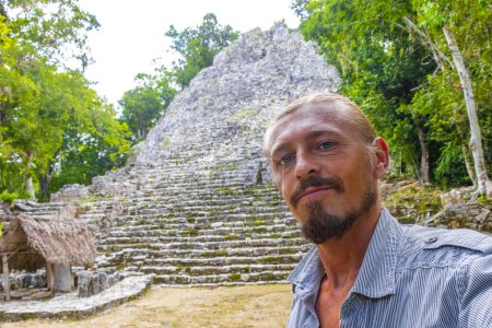 Foto de Hombre turista en Coba Maya Ruinas del antiguo edificio y pirámide Nohoch Mul en la selva tropical en el municipio de Coba Tulum Quintana Roo México. - Imagen libre de derechos