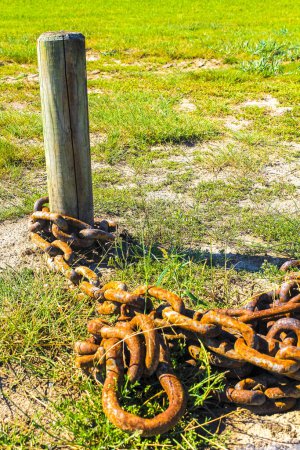 Foto de Gran cadena oxidada en estaca de madera en prado en Wremen Wurster Costa del Mar del Norte Wursten Cuxhaven Baja Sajonia Alemania. - Imagen libre de derechos