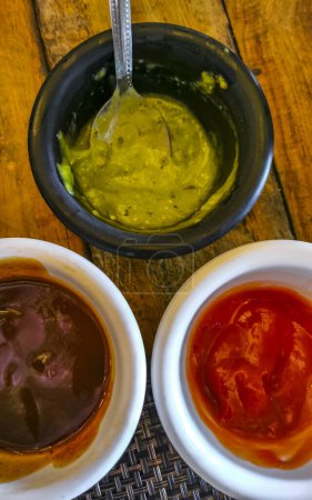 Foto de 3 salsas verde cilantro rojo ketchup y barbacoa en Playa del Carmen Quintana Roo México. - Imagen libre de derechos