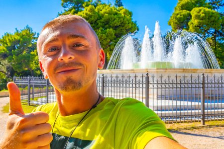 Male tourist handsome man in front of the Congress Center Building Zappeion Historic buildings fountain well in Athens Attica Greece.