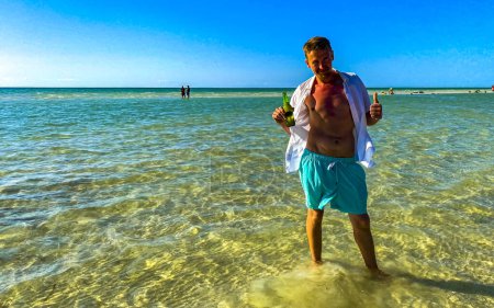Photo for Handsome sexy male tourist man takes selfie photo with panorama landscape view on beautiful Holbox island sandbank and beach with waves turquoise water and blue sky in Mexico. - Royalty Free Image
