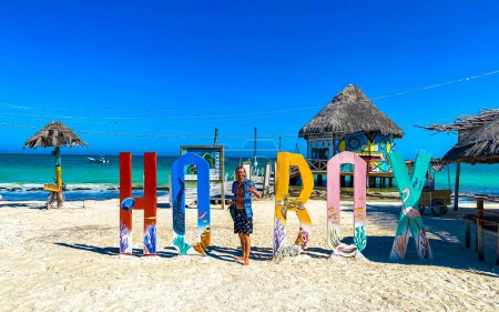 Foto de Cartas de bienvenida coloridas y signo en el hermoso banco de arena de la isla Holbox y la playa con olas de agua turquesa y cielo azul en Quintana Roo México. - Imagen libre de derechos