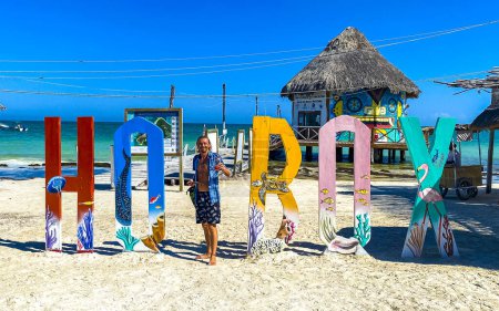 Foto de Cartas de bienvenida coloridas y signo en el hermoso banco de arena de la isla Holbox y la playa con olas de agua turquesa y cielo azul en Quintana Roo México. - Imagen libre de derechos