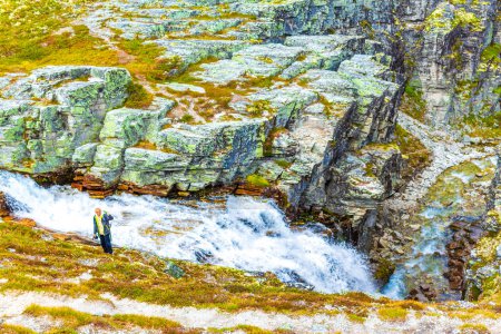 Young hiker and beautiful summer landscape panorama with mountains river lake rocks and hiking trail of Rondane National Park in Ringbu Innlandet Norway in Scandinavia.