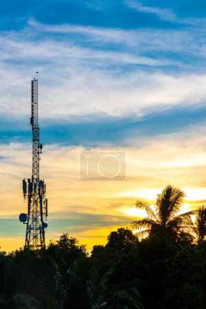 Red white 5G tower with blue sky background radiation kills us with sunset palm tree sky background in Zicatela Puerto Escondido Oaxaca Mexico.