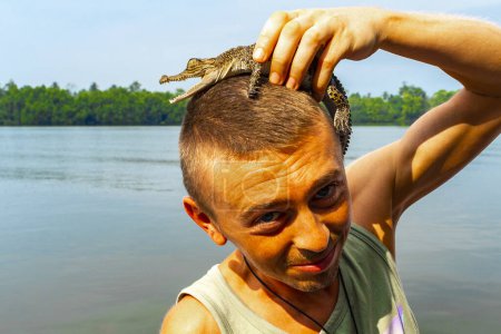 Touriste homme avec bébé crocodile alligator dans ses mains à la rivière Bantota Ganga à Bentota Beach Galle District Province du Sud Sri Lanka.