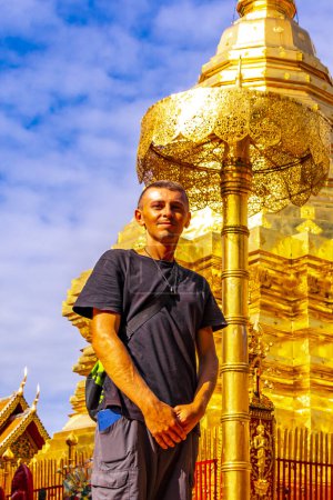 Schöner Mann männlicher Tourist bei der goldenen Gold Stupa Pagode Wat Phra That Doi Suthep Tempelbau in Chiang Mai Amphoe Mueang Chiang Mai Thailand in Südostasien Asien.
