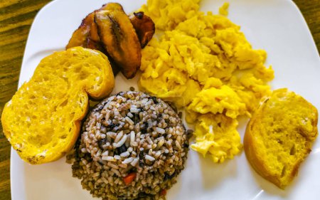Typical Costa Rican food dish Rice Banana Scrambled eggs Beans and bread in Alajuela Costa Rica in Central America.