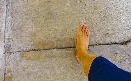 Walking on the pavement rocks stones feet barefoot in Zicatela Puerto Escondido Oaxaca Mexico.